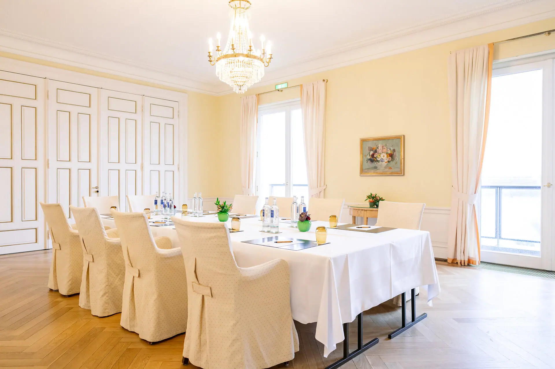 Gartenzimmer Louis C. Jacob Ein Raum mit einem Tisch und Stühlen, dekoriert mit einer Tischdecke und einer Vase.