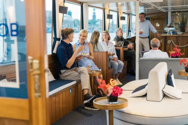 Mehrere Personen sitzen an Bord der Barkasse MS Jacob.