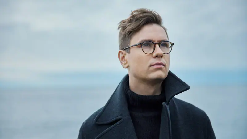 Ein Mann mit Brille und Mantel.