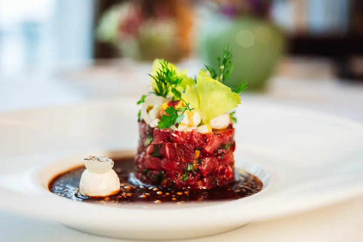 Ein Teller mit kunstvoll angerichteter Speise auf einem Tisch.